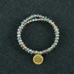 Primer plano detallado de la elegante pulsera de cuentas multicapa con colgante de loto.