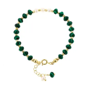 Gedetailleerd overzicht van groene malachiet edelsteen kralen armband met gouden accenten en parels.