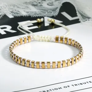 Detailopname van een stijlvolle boho kralenarmband met gouden rechthoekige kralen.