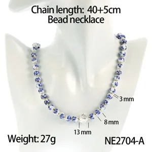 Detail view of a chic blue and white ceramic bead necklace with metallic pendant and chain.