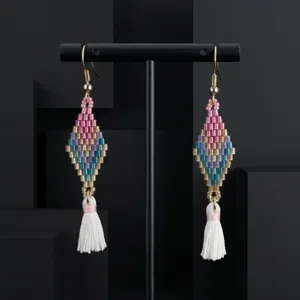 Close-up detail of handmade bohemian beaded tassel earrings featuring colorful geometric diamond patterns.