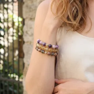 Vista detallada en primer plano de pulseras de cuentas de piedra natural en capas, estilo retro.