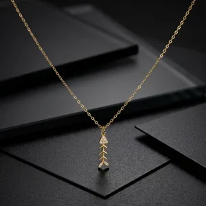 Vue détaillée d'un collier fin en or en forme d'arête de poisson avec des zircons brillants.