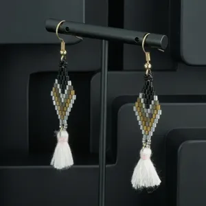 Handmade bohemian beaded tassel earrings with geometric diamond pattern and white fringe detail.