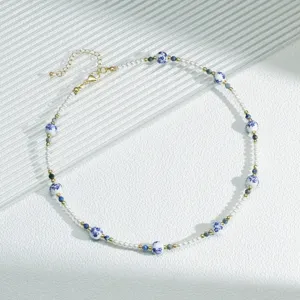 Close-up of new Chinese blue and white ceramic bead necklace with pearls and gold accents.
