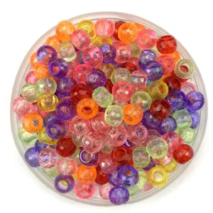 Close-up detail view of colorful faceted plastic craft beads inside a clear round tray.