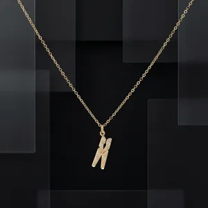 Gros plan du collier pendentif arête de poisson en zircon or 18k détail design.