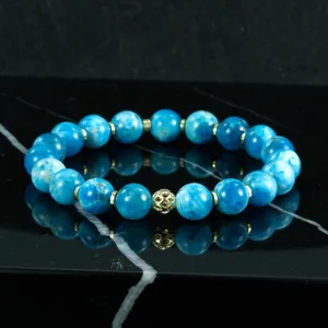 Vista detallada de la pulsera de cuentas de piedra natural azul con separadores metalicos dorados.