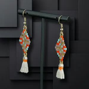 Close-up of bohemian beaded tassel earrings, colorful diamond pattern, elegant jewelry detail.