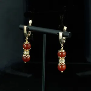 Vista detallada de pendientes retro de cuentas de ágata roja con metal dorado y circonita.