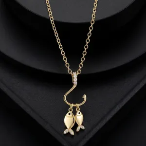 Gros plan détaillé sur un beau collier doré avec un pendentif hameçon poissons zircon.