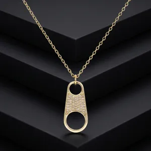 Vue détaillée du collier pendentif languette en zircon plaqué or sur socle noir.