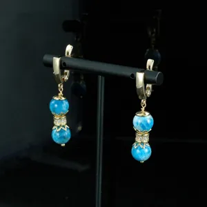 Pendientes colgantes vintage dorados de piedra natural de doble cuenta con elegantes estrás.