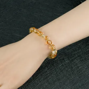 Pulsera de cuentas de cristal natural con separador dorado, elegante detalle en la muñeca.