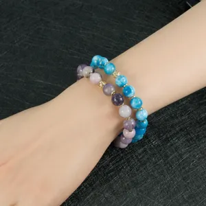 Detalle de muñeca con pulsera de cuentas de piedra natural multicolor y espaciadores metálicos.
