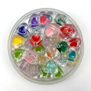 Primo piano dettagliato di perle a cuore in acrilico trasparente colorato con goccia d'olio.
