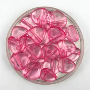 Detailed close-up of translucent pink heart-shaped acrylic beads with horizontal hole design for DIY crafts.