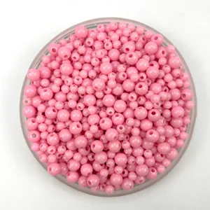 Close-up detail view of pink acrylic plastic beads for DIY jewelry and bracelets making.