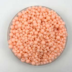 Close-up detail of 4-6mm pastel pink acrylic plastic round beads for DIY jewelry making.