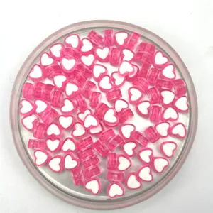 Close-up of pink and white heart-shaped acrylic beads, perfect for DIY jewelry making.