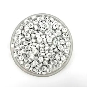 Acrylic letter beads detail shot showing clear alphabet prints on white round beads.