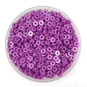 Close-up detail of purple polymer clay spacer beads, flat round DIY accessory for phone cases.
