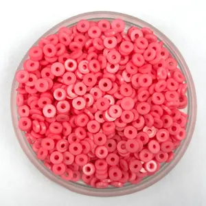 Pink flat round polymer clay spacer beads in clear container for phone case DIY craft supplies