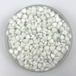 Close-up detail shot of white pearl heart plastic beads for DIY handmade jewelry.