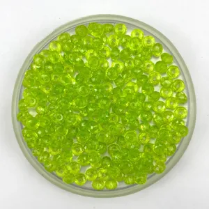 Close-up detail of lime green acrylic wheel beads in a clear tray for DIY crafts and curtains.