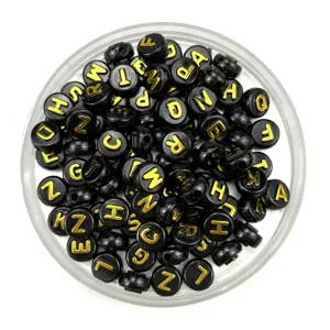 Black round flat alphabet beads with gold embossed letters, ideal for DIY jewelry making.
