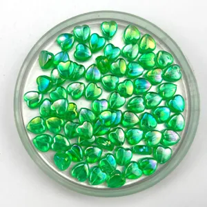 Close-up of shiny green AB iridescent heart acrylic beads for DIY jewelry making.