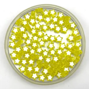 Close-up detail of yellow acrylic star loose beads with white center, ideal for DIY jewelry crafts.