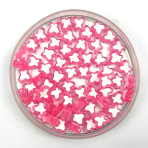 Close-up detail of pink and white acrylic butterfly beads for DIY jewelry making and crafts.