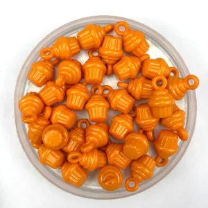 Détail de perles DIY en forme de petit gâteau orange, accessoires en plastique pour loisirs créatifs.