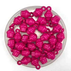 Détail de perles pendentifs en plastique en forme de cupcake rose pour la fabrication de bijoux.