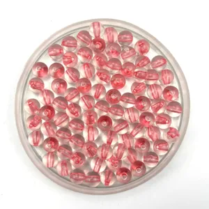 Close-up detail view of pink acrylic core-filled round beads in clear tray for DIY jewelry making.
