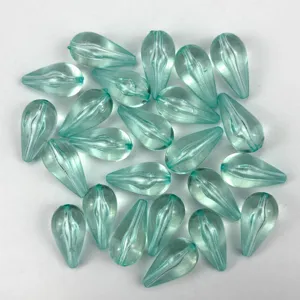 Detailed close-up of light blue teardrop acrylic beads, transparent DIY jewelry accessory.