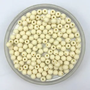 Close-up detail of matte acrylic round seed beads in a tray, perfect for DIY jewelry making.