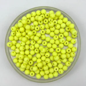 Close up of matte yellow acrylic round beads in container, ideal for DIY handmade crafts.