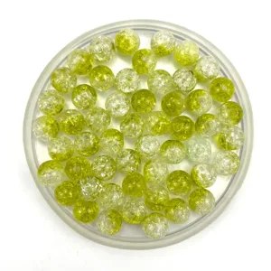 Detail view of yellow-green crackle glass beads for handmade DIY jewelry crafting and bracelets.