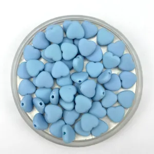Close-up detail of light blue matte heart beads, perfect for DIY bracelets and jewelry making.