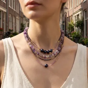 Detailed shot of layered amethyst chip bead seed bead and dark pearl necklace, retro chic design.