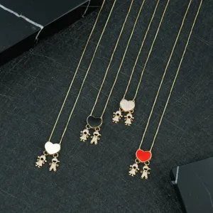 Close-up detail of exquisite gold-tone heart pendant necklaces with cute boy and girl charms.