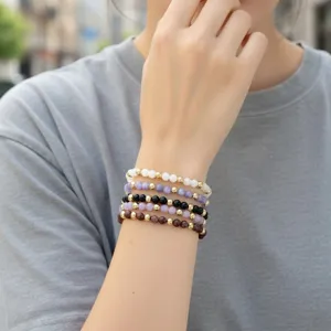 Gestapelde halfedelsteen kralen armband set met gouden accentkralen, detailgezicht.