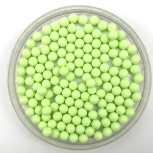 Close-up view of light green solid plastic round acrylic beads detail and smooth texture.