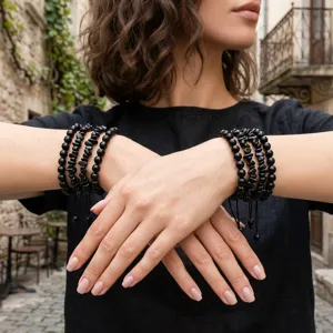 Gedetailleerd overzicht van handgemaakte zwarte edelsteen kralen gestapelde armbanden.