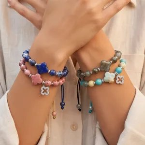Gedetailleerde close-up van gelaagde edelsteen kralen armbanden met gelukkige klaverbedels.