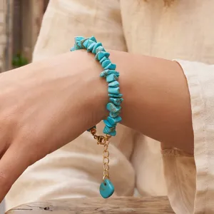 Gedetailleerde foto van onregelmatige turquoise stenen armband met gouden verstelbare ketting.