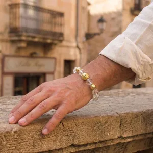 Close-up detail shot of beaded bracelet with clear crystal and textured gold beads on wrist.