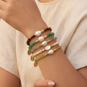 Gelaagde kralenarmbandset met onregelmäßige zoetwaterparels en schattige metalen bedels.